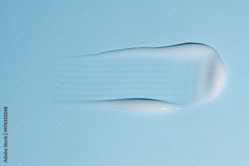 Texture of white cream on blue background. Smear of moisturizer close up. Lotion swatch. Beauty skin care product smear smudge. SPF sunscreen cream sample on blue background Texture of white cream on blue background. Smear of moisturizer close up. Lotion swatch. Beauty skin care product smear smudge. SPF sunscreen cream sample on blue background