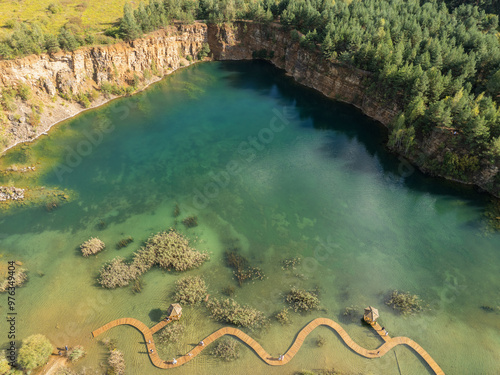 Aerial drone photo of Quarry turquiose lake colour, open pit mining in Park Grodek, Jaworzno. Poland. Turquiose Water and Wooden Bridge on lake. Polish Maldives Park Grodek in Jaworzno from drone. photo