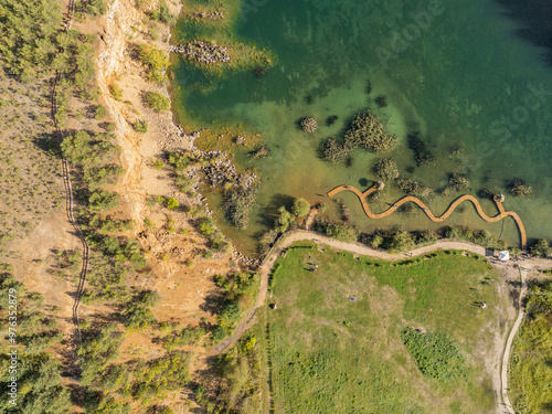 Aerial drone photo of Quarry turquiose lake colour, open pit mining in Park Grodek, Jaworzno. Poland. Turquiose Water and Wooden Bridge on lake. Polish Maldives Park Grodek in Jaworzno from drone. photo