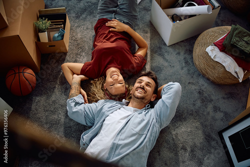 Above view of happy couple resting on floor at their new home. photo