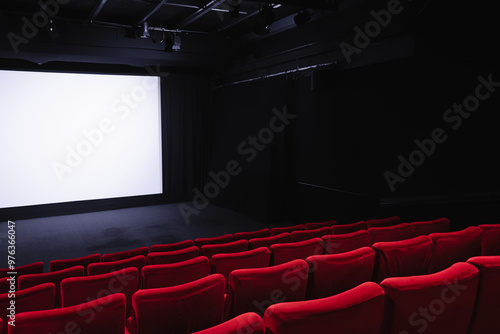 Cinema blank wide screen and empty red chairs