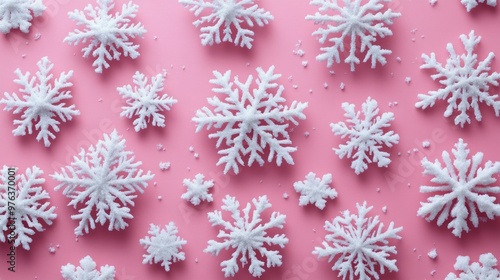 Decorative white snowflakes scattered on a pink background for festive winter...