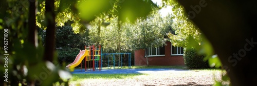 A quiet playground with colorful slides and a jungle gym nestled among lush green trees, providing a serene and peaceful environment for children to play. photo