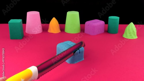 Very Satisfying and Relaxing Kinetic Sand ASMR video. Cutting anti stress macro close up colorful Kinetic Sand with a Knife. ASMR sounds. photo