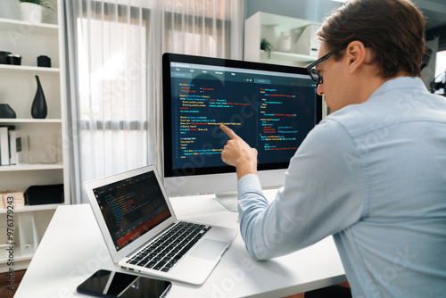 IT developer selecting by point on coding online software development information on pc comparing with laptop screen of new code program's update version firmware overall system project. Pecuniary.