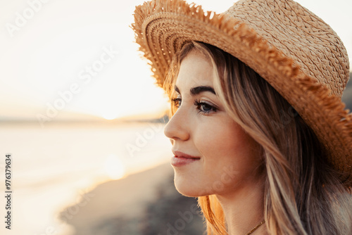 Portrait of one young woman at the beach looking at the sea enjoying free time and freedom outdoors. Having fun relaxing and living happy moments.. #976379634