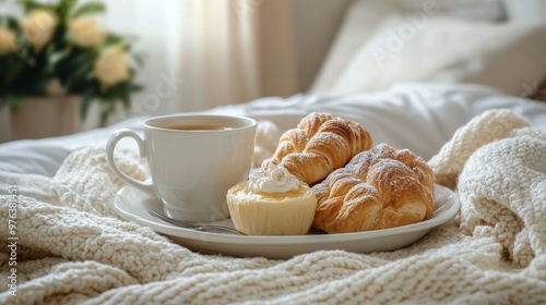 Cozy breakfast in bed: coffee, croissants, and a cupcake on a fluffy blanket ...