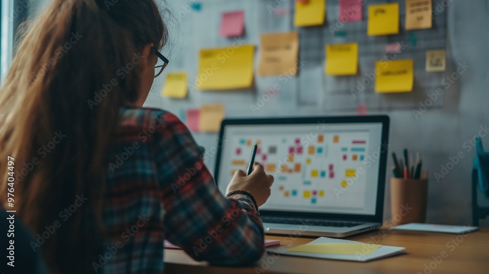 At a desk, using a laptop and problem-solving frameworks, a person formulates their problem-solving techniques. At a desk, using a laptop and problem-solving frameworks, a person formulates their problem-solving techniques.