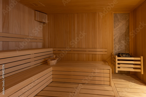 Interior of the Finnish sauna, classic wooden sauna with hot steam. Sauna room at hotel SPA center. Wooden interior baths, wooden benches and sun loungers sauna accessories, spa complex.