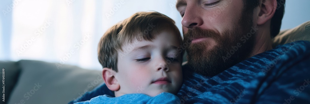 A father rests peacefully on the couch with his young son sleeping on his chest, capturing a tender moment of familial bond and intimacy in a serene setting. A father rests peacefully on the couch with his young son sleeping on his chest, capturing a tender moment of familial bond and intimacy in a serene setting.