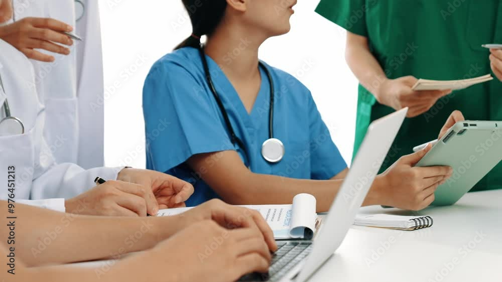 Professional group of medical working and planning medical treatment or healthcare system at hospital table together. Teamwork lead to successful illness and sickness treatment. Slow motion. Rigid. Professional group of medical working and planning medical treatment or healthcare system at hospital table together. Teamwork lead to successful illness and sickness treatment. Slow motion. Rigid.