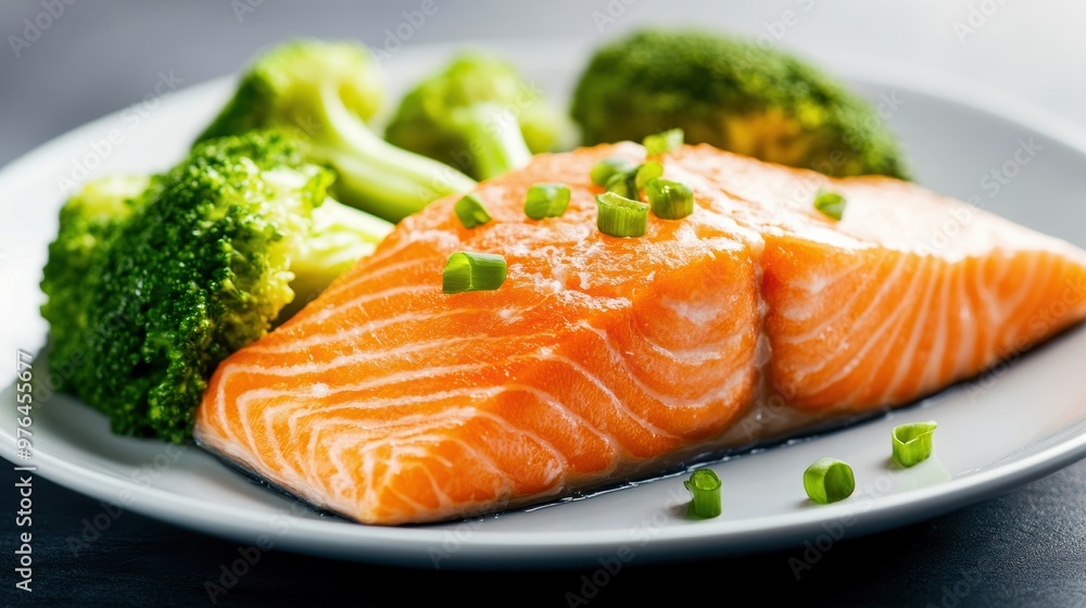 A delicious serving of salmon fillet paired with fresh broccoli, showcasing a healthy and vibrant meal. A delicious serving of salmon fillet paired with fresh broccoli, showcasing a healthy and vibrant meal.