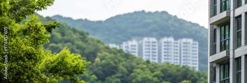 Wallpaper Mural A serene view of high-rise apartment buildings in the foreground with lush green mountains in the background providing a contrast between urban and natural landscapes. Torontodigital.ca