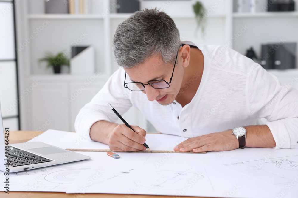 Architect making engineering drawing at wooden table in office Architect making engineering drawing at wooden table in office