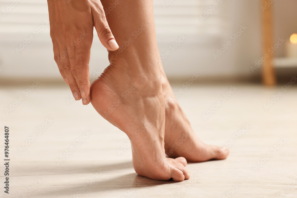 Woman touching her smooth feet on floor, closeup. Body care Woman touching her smooth feet on floor, closeup. Body care