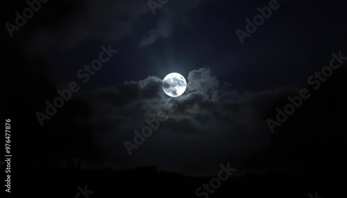 A tranquil moonlit night, where thin clouds veil most of the moon, allowing only delicate rays of light to break through, illuminating the stillness of the darkened landscape