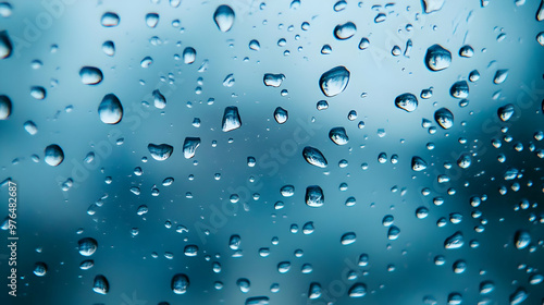 Close-up of water droplets on a glass surface, creating a blurred background with a tranquil and refreshing ambiance.