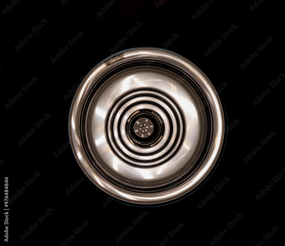 Symmetrical Chrome Hubcap on Black Background Symmetrical Chrome Hubcap on Black Background