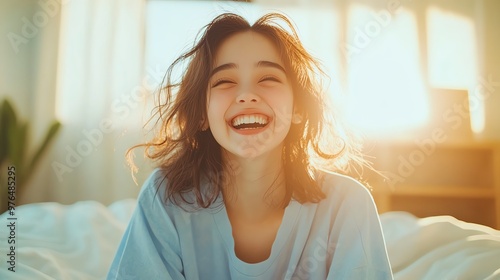 A young woman smiles brightly in soft morning light, embodying joy and positivity in a cozy bedroom setting.