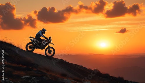 Thrilling dirt bike adventure on a mountain against a stunning orange sunset sky