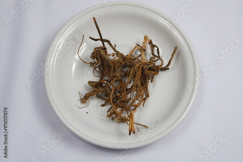 Dried Herbal Roots on White Plate for Traditional Medicine