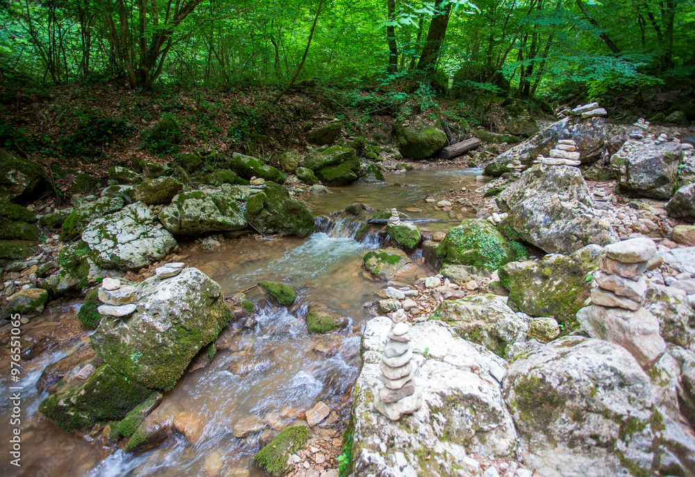canyon of a river in the mountains, a riverbed with shallow water and stone figures canyon of a river in the mountains, a riverbed with shallow water and stone figures