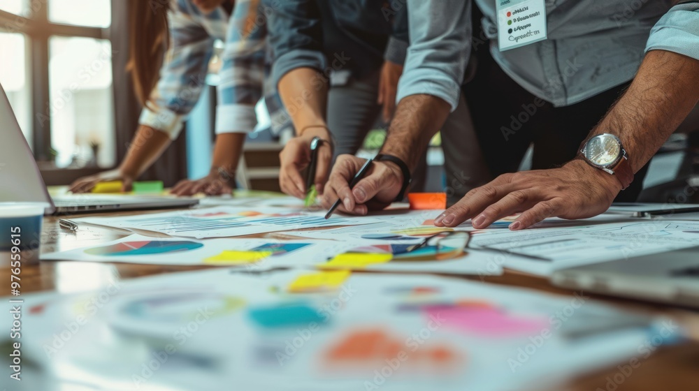 A business team working on a strategic plan using charts and graphs. A business team working on a strategic plan using charts and graphs.
