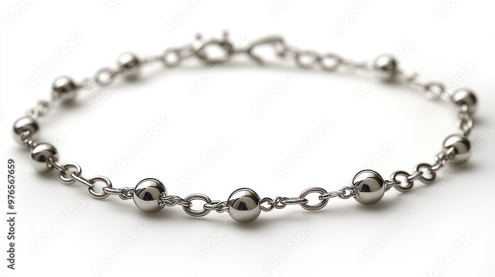 A silver bracelet featuring spherical beads linked by chains. A silver bracelet featuring spherical beads linked by chains.