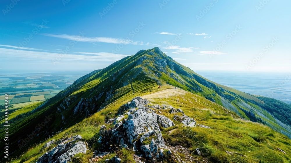Fototapeta premium A breathtaking view from the top of a mountain peak with a clear sky