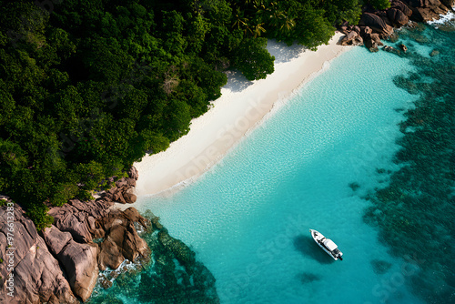 Aerial view of a white sandy beach and turquoise water with a boat anchored in the bay. photo