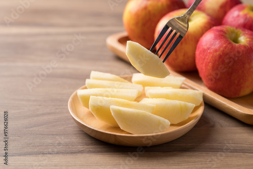 Sliced red apple fruit (Envy apple) on wooden plate with fork ready to eating, Healthy fruit