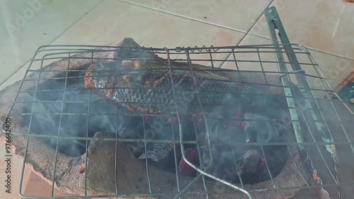 Wallpaper Mural Cooking tilapia fish by grilling it on a traditional pottery kitchen Torontodigital.ca