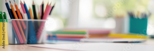 This image showcases a collection of colorful pencils, neatly organized in containers, set upon a brightly lit desk with paper sheets, representing creativity and work space organization.