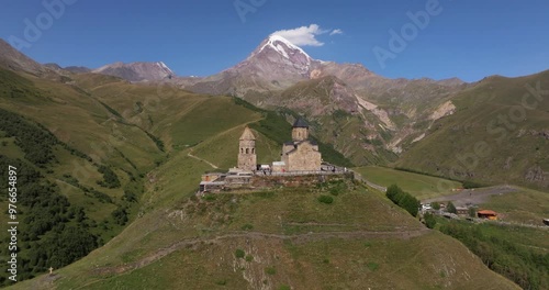 Gergeti Trinity Church on Beautiful Summer Day. Mount Kazbek in Background photo