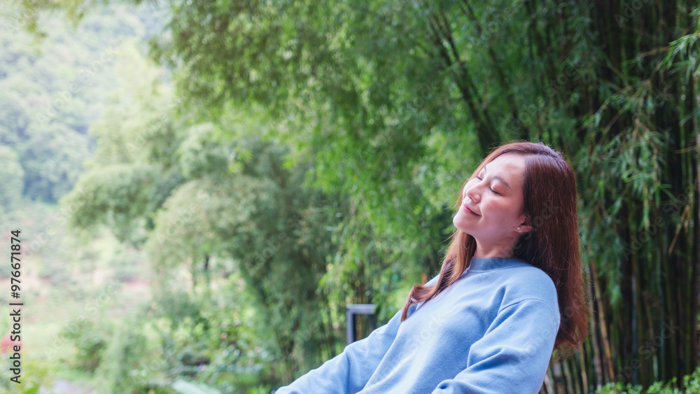 Portrait image of a young woman with closed eyes enjoying and relaxing with nature Portrait image of a young woman with closed eyes enjoying and relaxing with nature