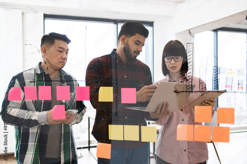 Group of young professionals collaborating on project in modern office ...