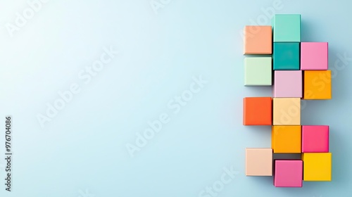 Colorful building blocks arranged creatively on a light blue background, ideal for playful and educational themes.
