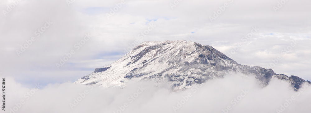 Obraz premium Paisaje de la cima del Iztaccíhuatl (Mujer Dormida) con nieve rodeado por nubes 