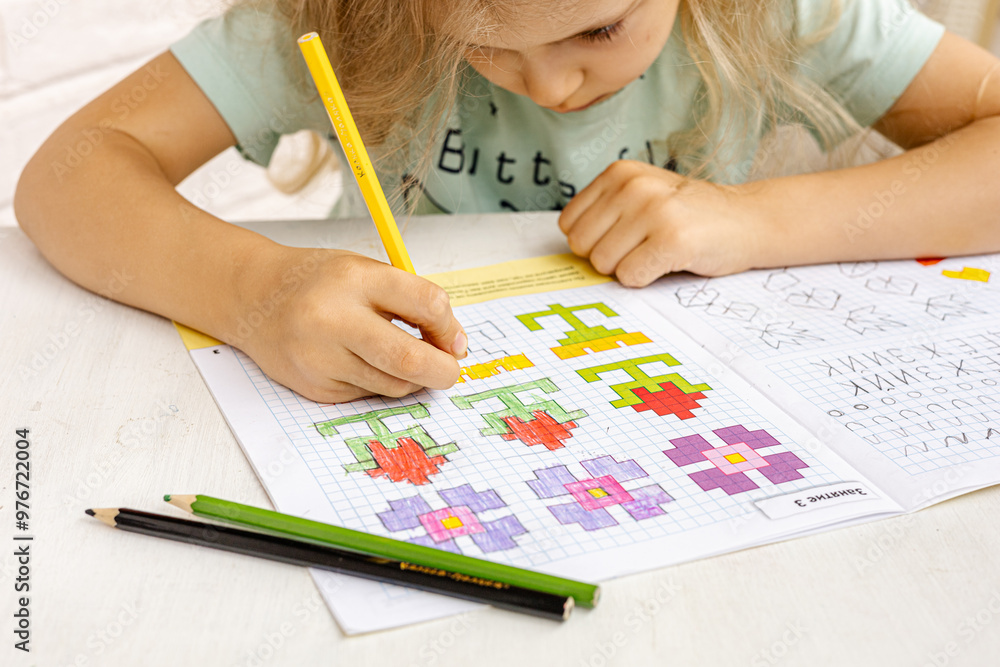 © Anna - A preschool girl sits at the table and draws by squares. Step-by-step drawing. Elementary school and education:  preschool education, child development concept. Early learning