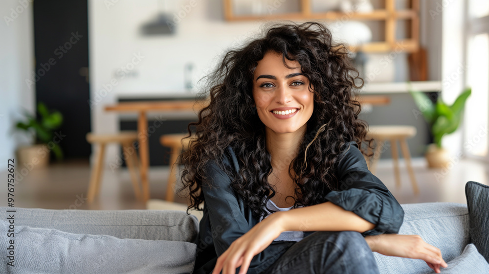 Curly haired brunette woman relaxing on the couch at home. Curly haired brunette woman relaxing on the couch at home.