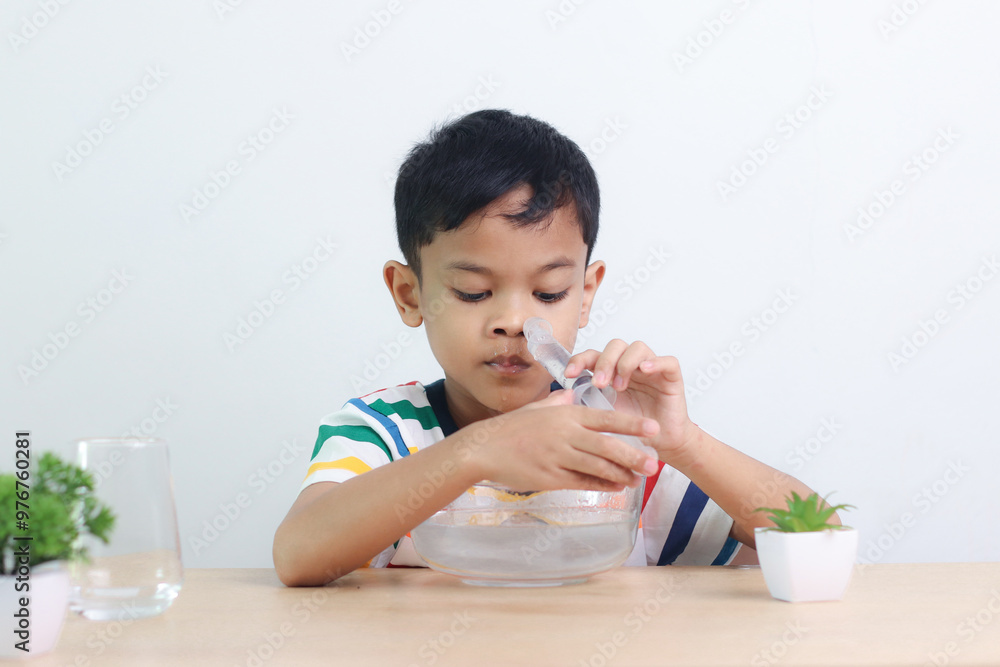 little asian boy saline nasal wash nose at home. little asian boy saline nasal wash nose at home.