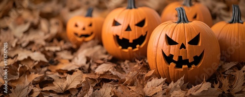Festive Halloween pumpkins with carved faces surrounded by autumn leaves, creating a spooky and cheerful atmosphere.