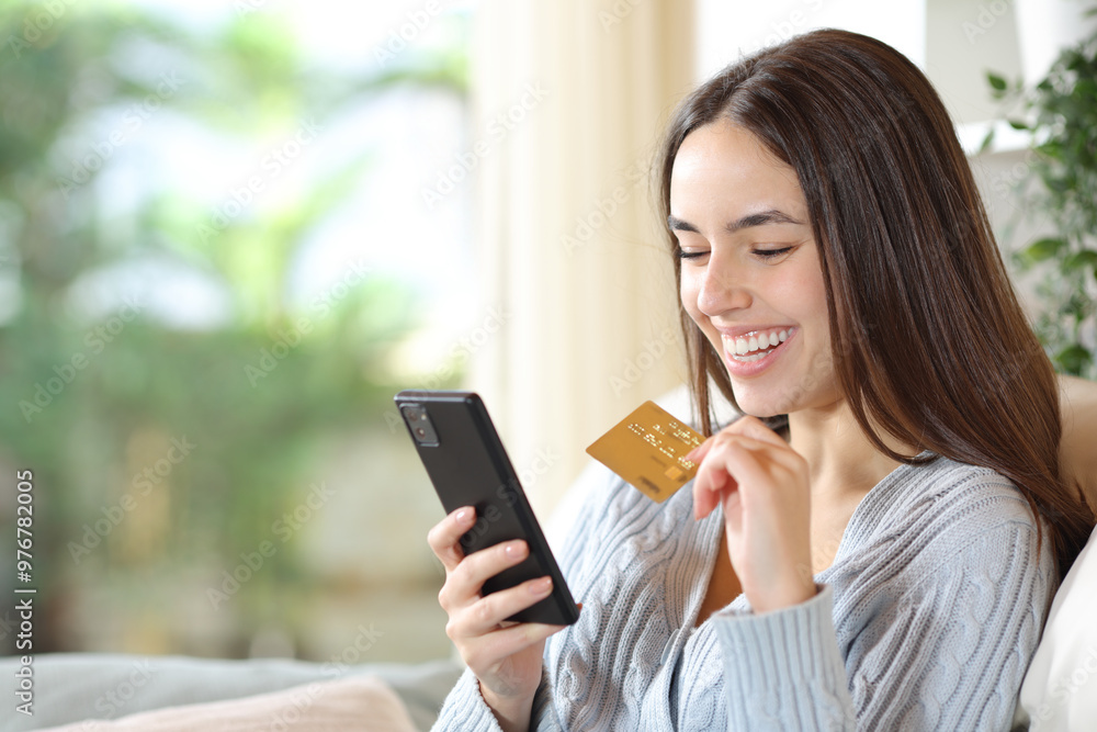 Happy woman on a couch buying online at home Happy woman on a couch buying online at home