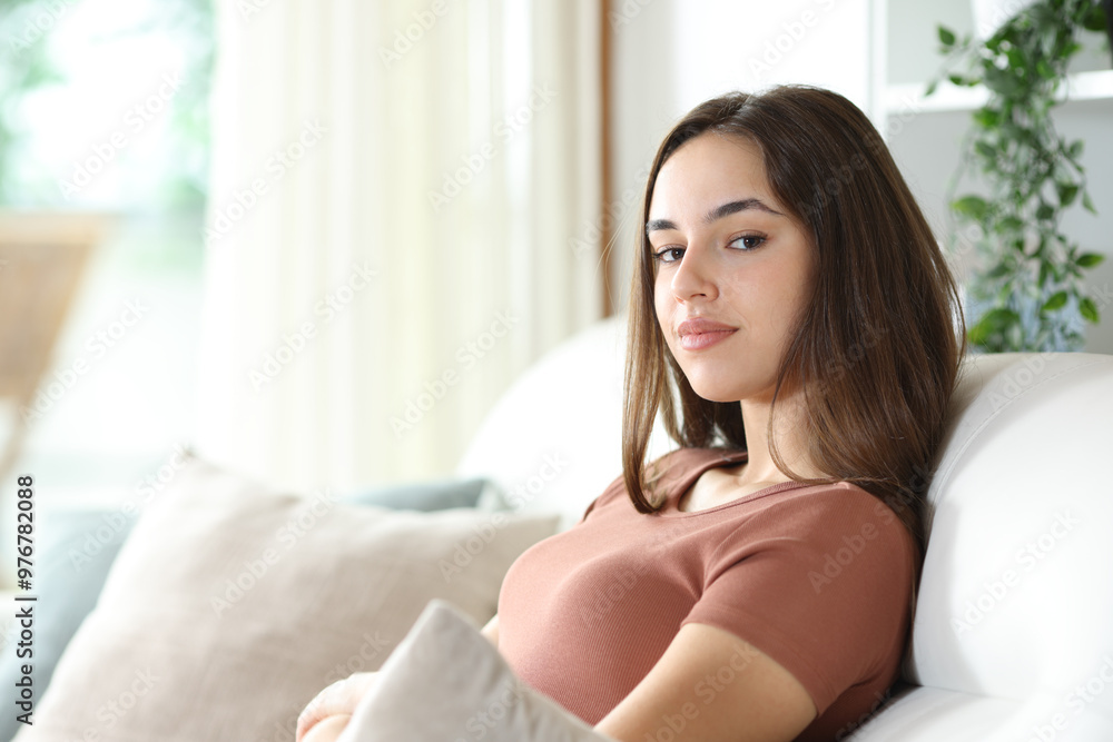 Serious woman sitting at home looking at camera Serious woman sitting at home looking at camera