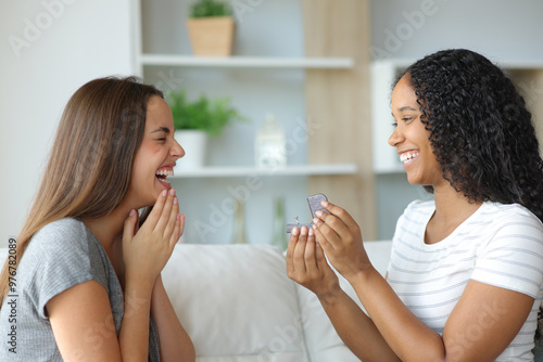 Happy interracial lesbian couple proposing marriage photo