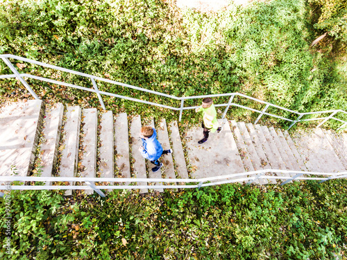 Aerial view of two runners running up the staris in the park. Morning running training for male friends. photo