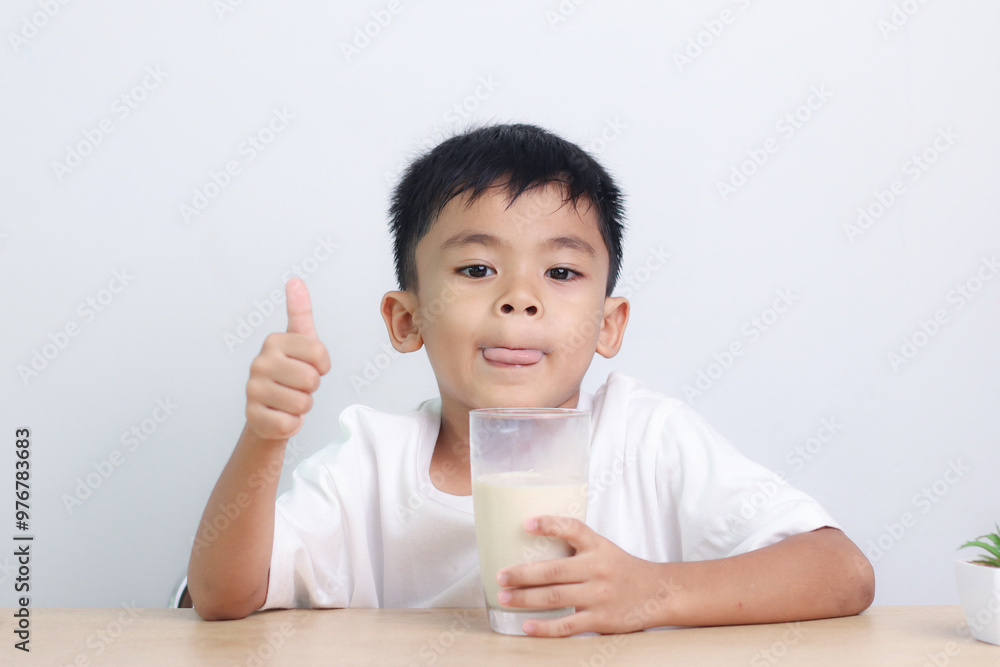 Asian little cute boy drinking milk. stays home with a smiling face, feels happy, and enjoys drinking milk. Asian little cute boy drinking milk. stays home with a smiling face, feels happy, and enjoys drinking milk.