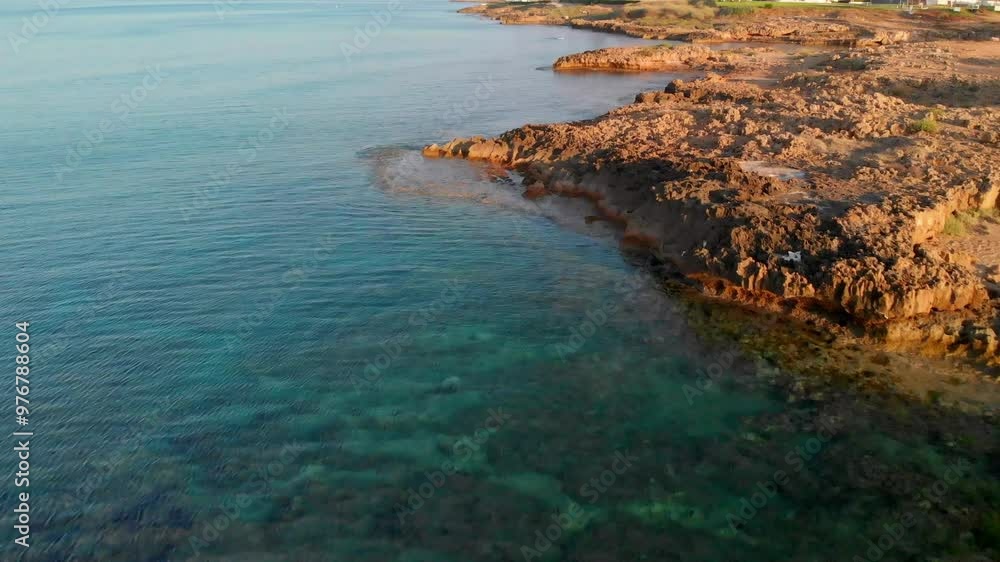 Low angle view of rocky shore in Cyprus, capturing rugged coastline and breaking waves. Low angle view of rocky shore in Cyprus, capturing rugged coastline and breaking waves.