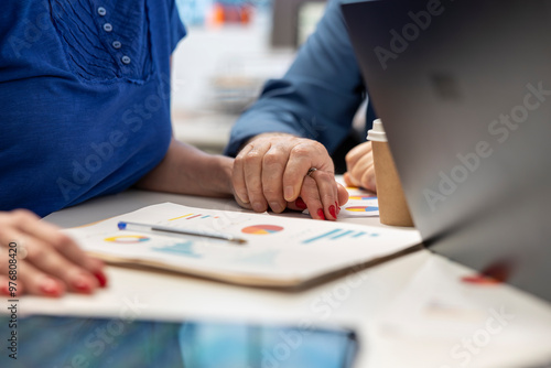 Senior man supporting his wife while they explore retirement plans with a broker, discussing future investment to secure pension and life savings. Professional insurance counseling.