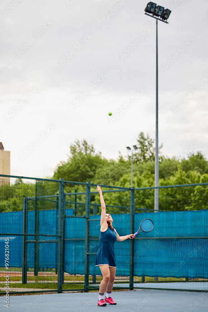 Fototapeta premium Young woman in motion on the tennis court